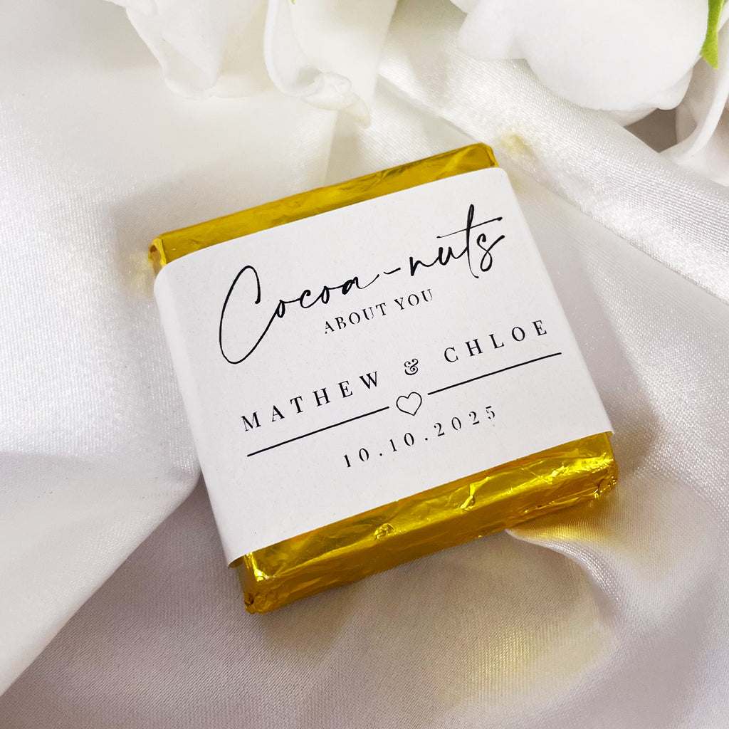 "Cocoa-nuts about you" minimalist wedding chocolates. Cute wedding favour ideas. Mini chocolate squares personalised with your names and date. Gold metallic foil wrapper.