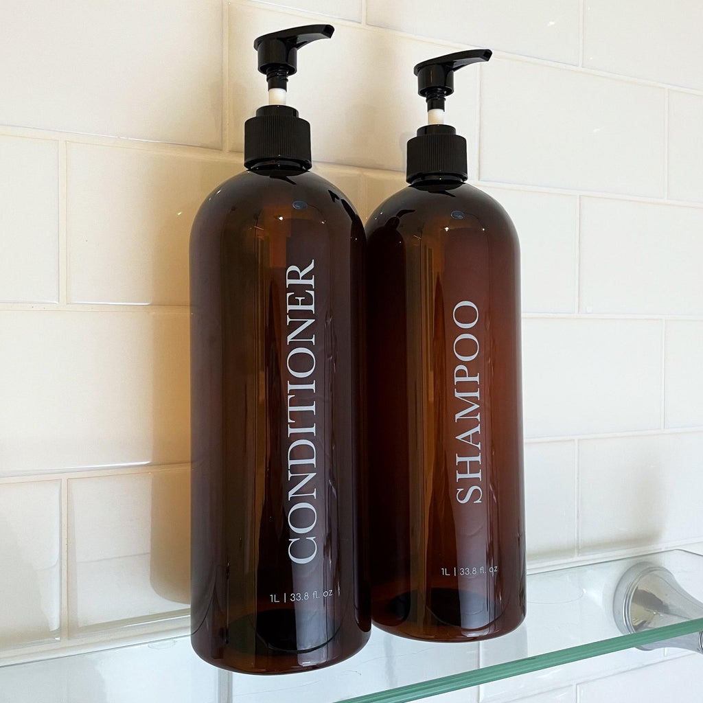 2 piece 1 litre bathroom bottles with bold serif design. Minimalist bathroom bottles for any bathroom. Brown bottle with white print and black pumps.