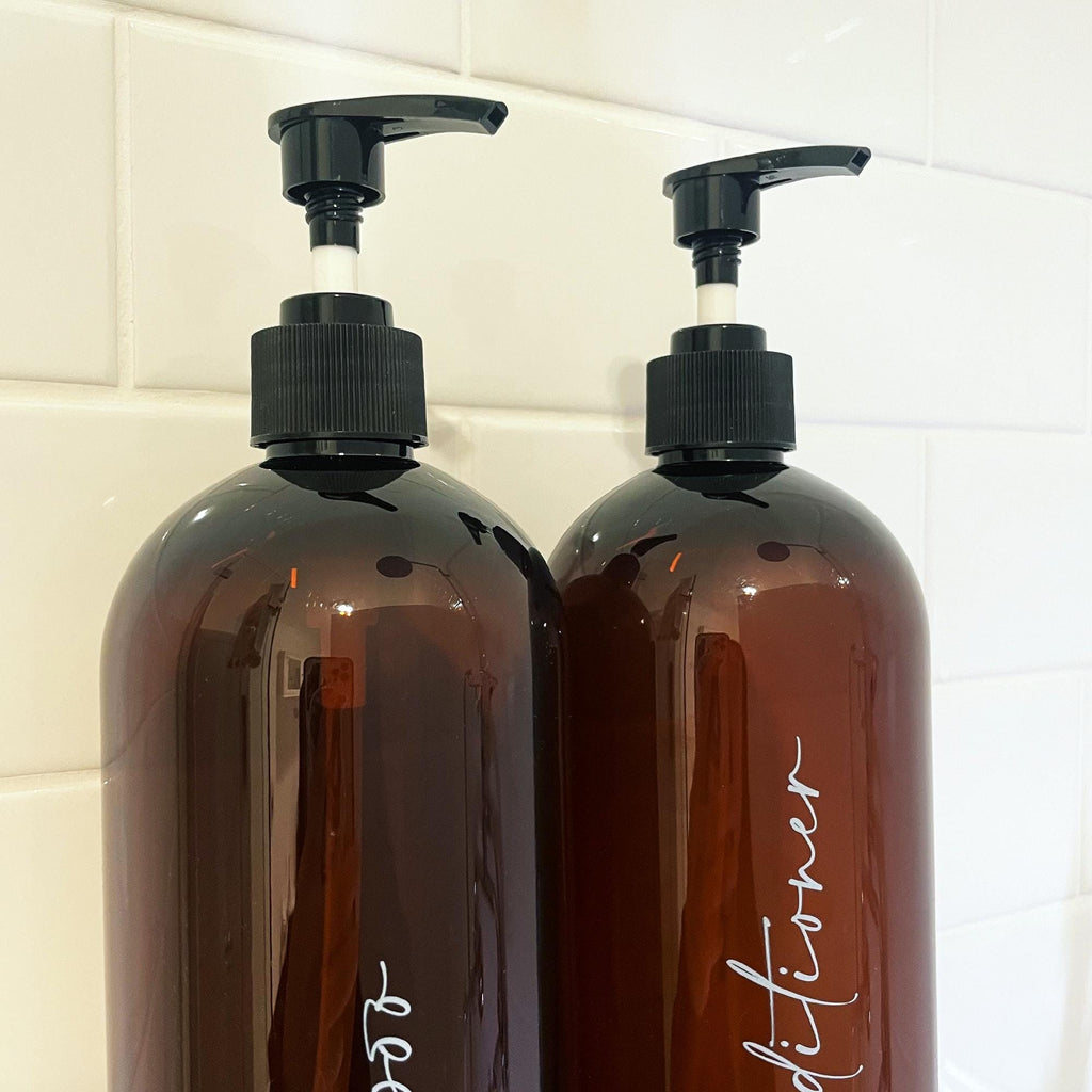 Custom brown and black bathroom pump bottles for refills. Refillable shampoo and conditioner bottles. Elegant and minimalist design.