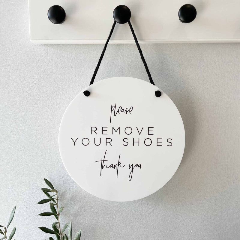 Round white hanging sign with 'Please Remove Your Shoes Thank You' text printed. Shoes off welcome sign for your home and entrance. 