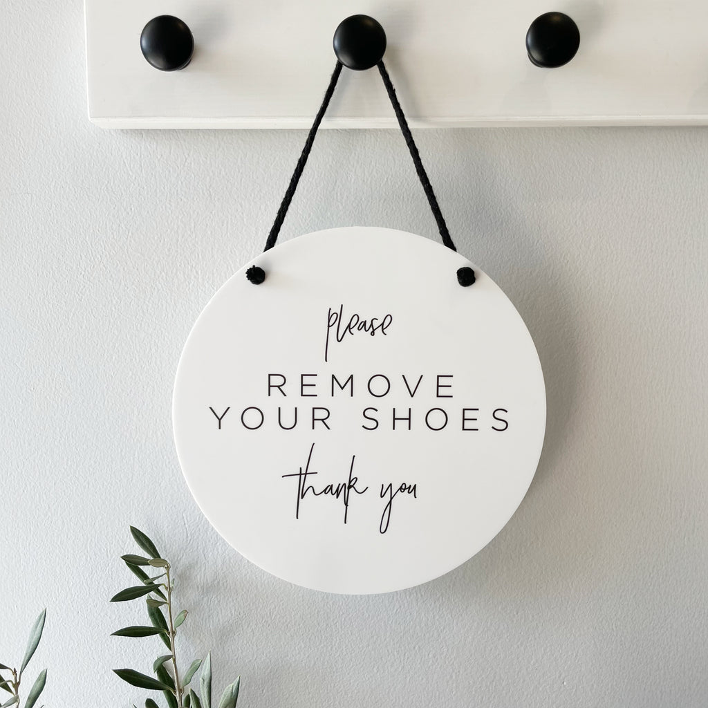 Round white hanging sign with 'Please Remove Your Shoes Thank You' text printed. Shoes off welcome sign for your home and entrance. 