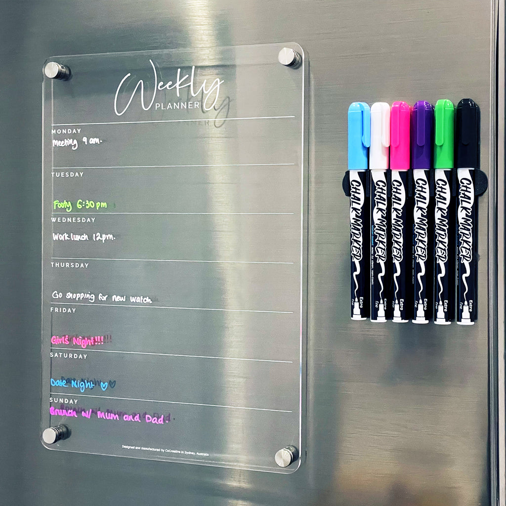magnetic weekly planner pictured with 6 coloured chalk markers on a stainless steel fridge. colour-code your plans or allocate colours to each family member  with our wide range of colours. 